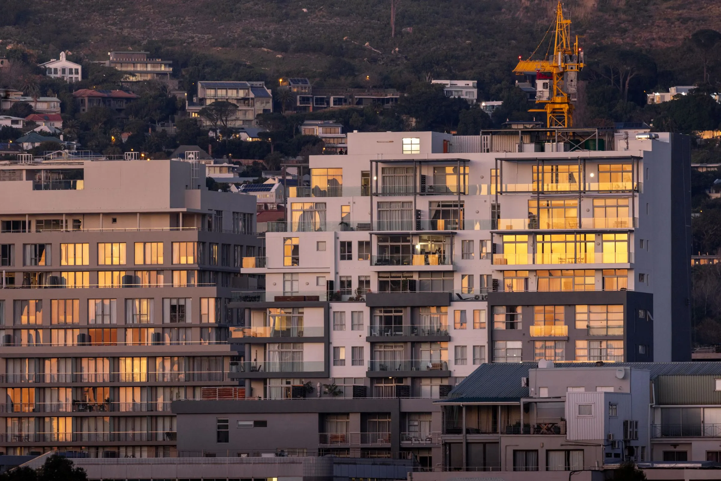 Blocks of flats in Cape Town catching the late sun, with houses on the hillside behind